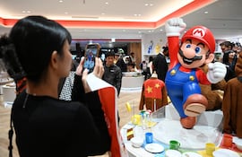 Esta foto de archivo, tomada el 4 de noviembre de 2025, muestra a una mujer tomando fotografías de una figura de Super Mario en la tienda Nintendo Tokyo, en Tokio.