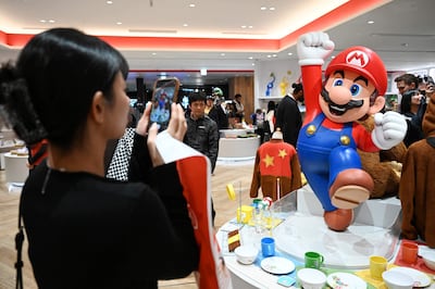 Esta foto de archivo, tomada el 4 de noviembre de 2025, muestra a una mujer tomando fotografías de una figura de Super Mario en la tienda Nintendo Tokyo, en Tokio.