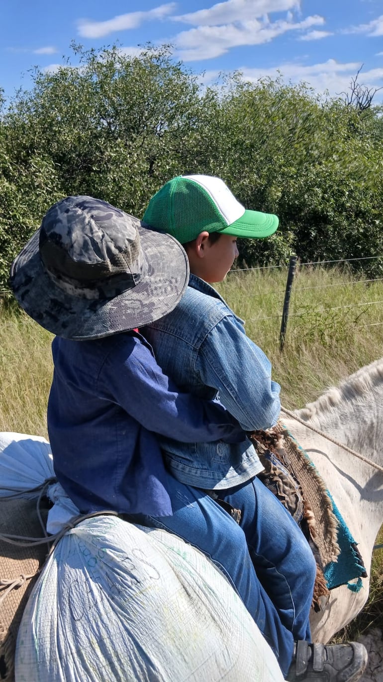 Enriquito el hijo de la docente (sombrero negro), montado a caballo ayudado por otro niño de la zona.
