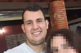Víctor Basualdo sonríe hacia la cámara en un entorno de reunión con paredes de ladrillo.