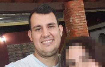 Víctor Basualdo sonríe hacia la cámara en un entorno de reunión con paredes de ladrillo.