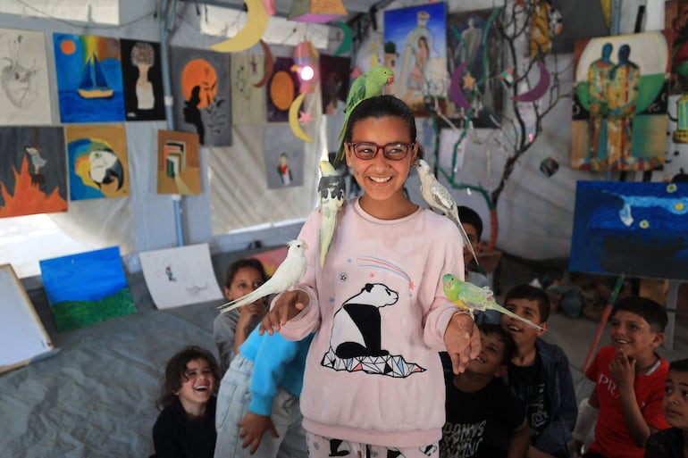 Niños palestinos desplazados participan en sesiones de apoyo psicológico en un estudio de arte que utiliza mascotas y aves en la zona de Al-Zawaida, en el centro de la Franja de Gaza, el 21 de abril de 2026.