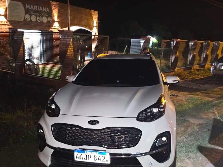 Camioneta Kia Sportage blanca estacionada frente al establecimiento 'MARIANA' en un ambiente nocturno.