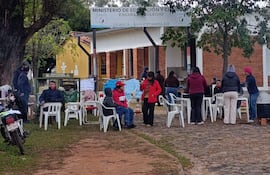 Un grupo de padres de familia se encuentra concentrado frente al portón de acceso a la institución
