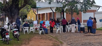 Un grupo de padres de familia se encuentra concentrado frente al portón de acceso a la institución