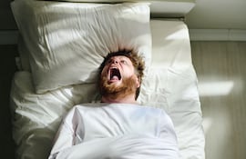 Hombre en la cama grita de dolor, imagen ilustrativa.