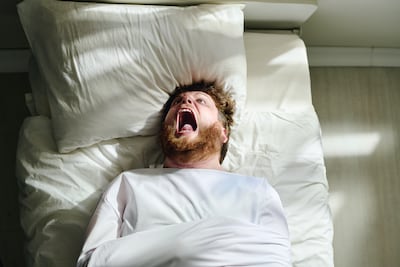Hombre en la cama grita de dolor, imagen ilustrativa.