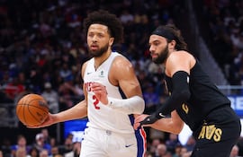 Cade Cunningham de los Detroit Pistons lleva el balón ante la marca de Max Strus.