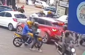 Uno de los delincuentes escapa con una caja que contiene aparatos celulares.