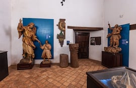 Estatuas de arte religioso en el interior del museo, destacando a un ángel dorado y un guerrero con estandarte.