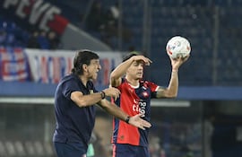 El entrenador de Cerro Porteño, Gustavo Costas da indicaciones a sus dirigidos, mientras el lateral Iván Ramírez segovia prepara la reposición manual,