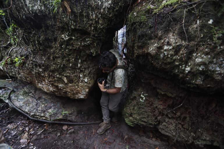 Un turista cruza un camino en medio de rocas en la reserva la Recebera y Pozos naturales en la región del Guaviare (Colombia).