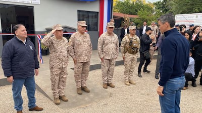 Santiago Peña en abrigo oscuro observa a cuatro militares en uniforme de camuflaje alineados en atención.