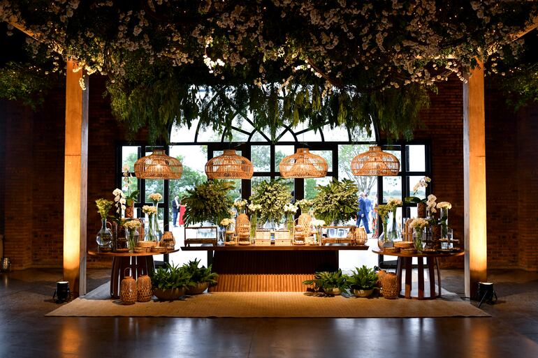 La fiesta de bodas fue decorada con arreglos de follaje natural y flores blancas por Karen Dalles.