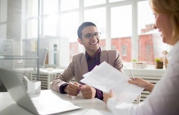 Un joven empresario de éxito y su colega discuten documentos o ideas de trabajo.