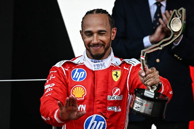 El piloto británico Lewis Hamilton, de Ferrari, celebra en el podio tras competir en el Gran Premio de Fórmula 1 de Mónaco. (Gabriel BOUYS / AFP)