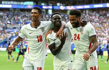 El delantero de Inglaterra Bukayo Saka (C) celebra tras anotar el quinto gol de su equipo con sus compañeros, el mediocampista Jude Bellingham y el defensor Reece James, durante el partido por el tercer puesto del torneo de fútbol de la Copa Mundial 2026 entre Francia e Inglaterra en el Miami Stadium de Miami.