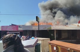 Una enorme nube de humo cubre el mercado municipal de Itauguá, donde trabajadores, pobladores y bomberos intentan desesperadamente sofocar el fuego