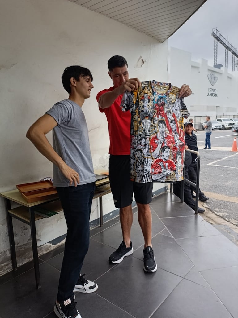 Óscar Tacuara Cardozo admirando la camiseta que le preparó el artista Ignacio Villaba. (Gentileza)