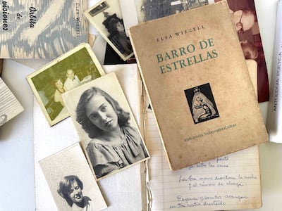 Libro 'Barro de Estrellas' de Elza Wiezell en una superficie blanca con fotografías y notas manuscritas alrededor.