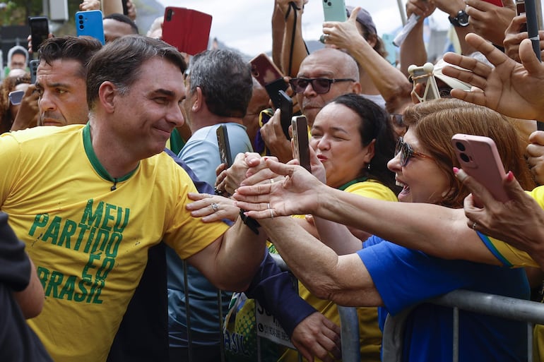  El candidato a la Presidencia de Brasil por el Partido Liberal, Flávio Bolsonaro, saluda a simpatizantes durante un evento de campaña este domingo, en la playa de Copacabana en Rio de Janeiro (Brasil). Bolsonaro, hijo del expresidente Jair Bolsonaro, inició su campaña para las elecciones presidenciales de octubre con duros ataques hacia el actual mandatario y aspirante a la reelección, Luiz Inácio Lula da Silva, y prometió tratar a los narcotraficantes como "terroristas". 
