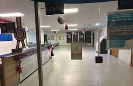 Espacio interior del IPS con mostrador y señalización de entrada y salida, adornos en colores patrios.