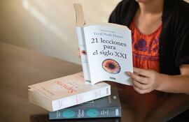 Una mujer lee el libro 21 lecciones para el siglo XXI, de Yuval Noah Harari.