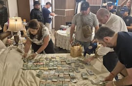 El fiscal Federico Leguizamón (camisa blanca) y sus funcionarios cuentan el dinero encontrado en la casa de Dalia López en Asunción.