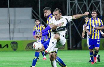 Marcelo Pérez, jugador de Sportivo Luqueño (i), disputa un balón con Juan Núñez, futbolista de Recoleta FC, en un partido de la fecha 9 del torneo Clausura 2025 de la Primera División de Paraguay en el estadio Luis Salinas, en Itauguá, Paraguay.