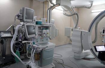 Sala de procedimientos médicos con equipos como monitor de signos vitales y máquina de anestesia, sin personas visibles.