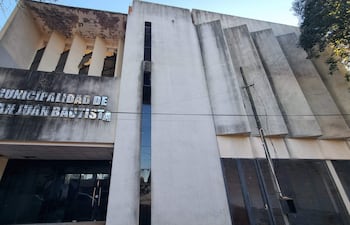 Fachada deteriorada del palacete municipal, con letrero visible y árboles al lado derecho.