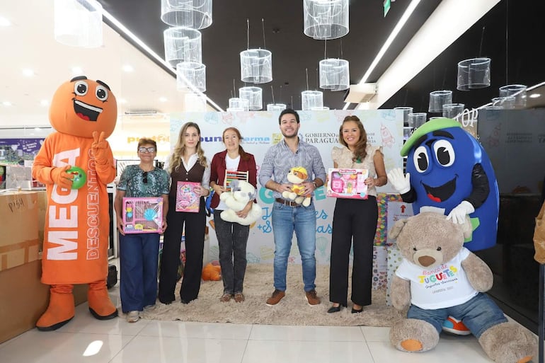 Personas sonrientes en un evento de donación de juguetes, con un personaje disfrazado, juguetes en mano y ambiente festivo.