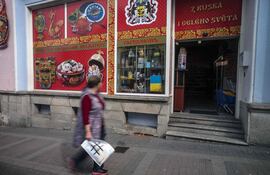 Una mujer pasa frente a una tienda rusa en Karlovy Vary, República Checa. Las ciudades balneario checas que figuran en la lista de la UNESCO están buscando clientes luego de una disminución dramática en su clientela extranjera debido a la pandemia de Covid y la guerra de Rusia contra Ucrania.