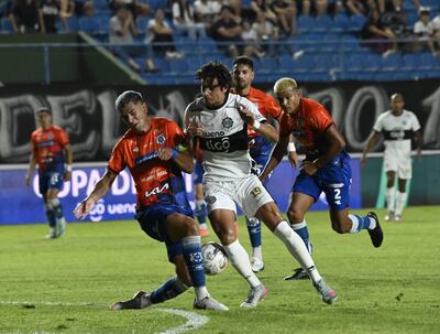  El zaguero  Pedro Sosa traba el balón ante la arremetida del atacante Adrián Alcaraz.