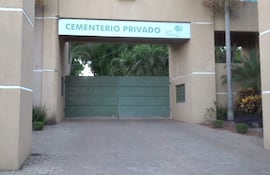 Entrada al cementerio privado Jardín Paraíso con letrero y puerta verde, rodeado de vegetación.