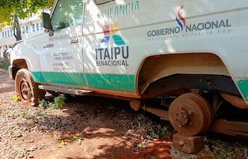 Ambulancia del Ministerio de Salud, con logos de Itaipú y Gobierno, en terreno descuidado, con llantas en mal estado.