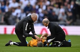 El paraguayo Diego Gómez, futbolista de Brighton, es asistido luego de sufrir una lesión en la rodilla izquierda al disputar un balón aéreo durante el partido frente a Tottenham por la fecha 33 de la Premier League en el estadio Tottenham Hotspur, en Londres, Inglaterra.