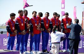 Integrantes del equipo de remo de Cuba reciben la medalla de bronce luego de una prueba el pasado domingo en la bahía de Asunción.
