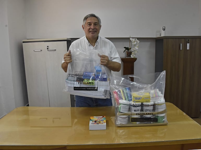 Luis Ramírez, el ministro de Educación, exhibe un par de kits escolares.