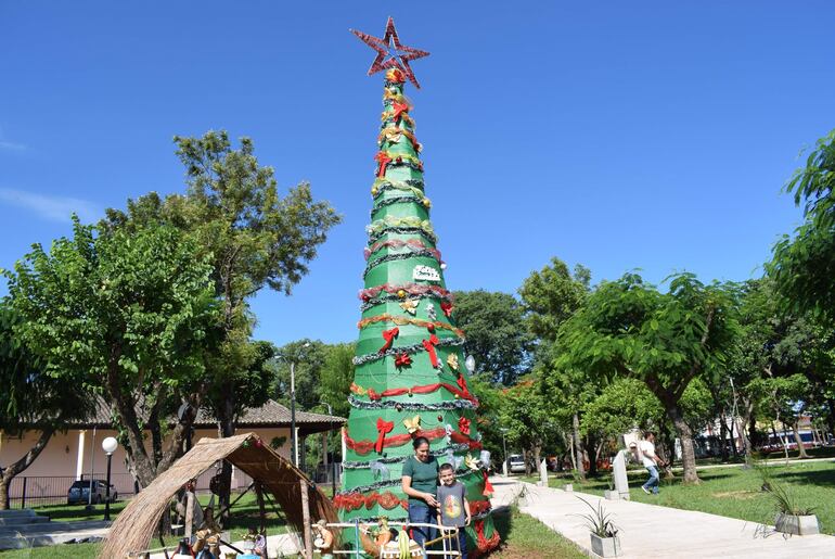 Los visitantes se toman fotografías junto al pesebre y el árbol navideños. 