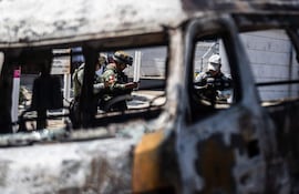 MEX5081. ACAPULCO (MÉXICO), 22/02/2026.- Integrantes de la Guardia Nacional y el ejército mexicano vigilan la zona donde fue incendiado un autobús presuntos integrantes del crimen organizado este domingo, en el balneario de Acapulco (México). La Secretaría de la Defensa Nacional de México confirmó el abatimiento de Nemesio Rubén Oseguera Cervantes, alias El Mencho, líder del Cártel Jalisco Nueva Generación (CJNG), lo que ocasionó reacción del grupo criminal realizando bloqueos y quema de vehículos. EFE/ David Guzmán