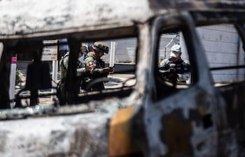MEX5081. ACAPULCO (MÉXICO), 22/02/2026.- Integrantes de la Guardia Nacional y el ejército mexicano vigilan la zona donde fue incendiado un autobús presuntos integrantes del crimen organizado este domingo, en el balneario de Acapulco (México). La Secretaría de la Defensa Nacional de México confirmó el abatimiento de Nemesio Rubén Oseguera Cervantes, alias El Mencho, líder del Cártel Jalisco Nueva Generación (CJNG), lo que ocasionó reacción del grupo criminal realizando bloqueos y quema de vehículos. EFE/ David Guzmán