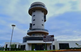 Edificio en forma de torre con señales que indican 'MIRADOR' y 'GALERIA DE ARTE'. El cielo está nublado.