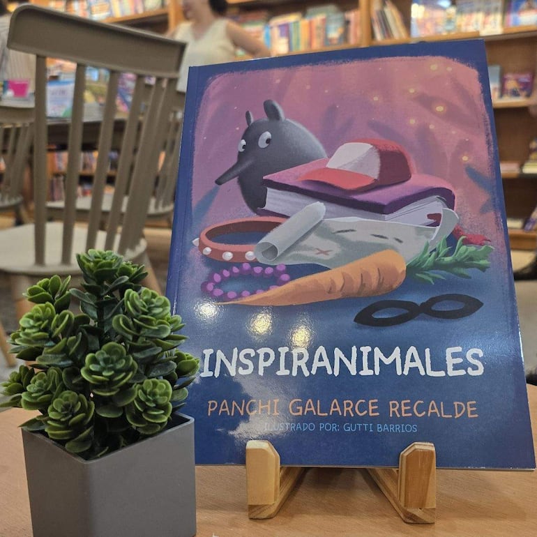 El libro 'Inspiranimal' sobre un atril con ilustraciones llamativas en una acogedora librería.