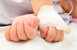 Manos de un bebé recibiendo suero.