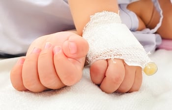 Manos de un bebé recibiendo suero.