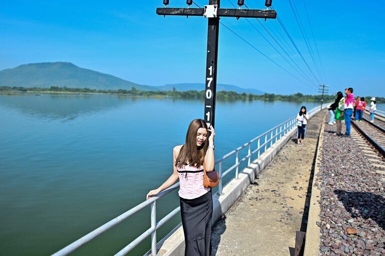 Una turista posa para una foto sobre la vías. 
