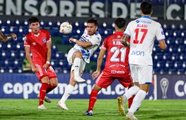 yo Edgardo Orzusa (7), futbolista de Nacional, pelea por el balón en un partido frente a Argentinos Juniors por la fase de grupos de la Copa Sudamericana 2024 en el estadio Defensores del Chaco, en Asunción.