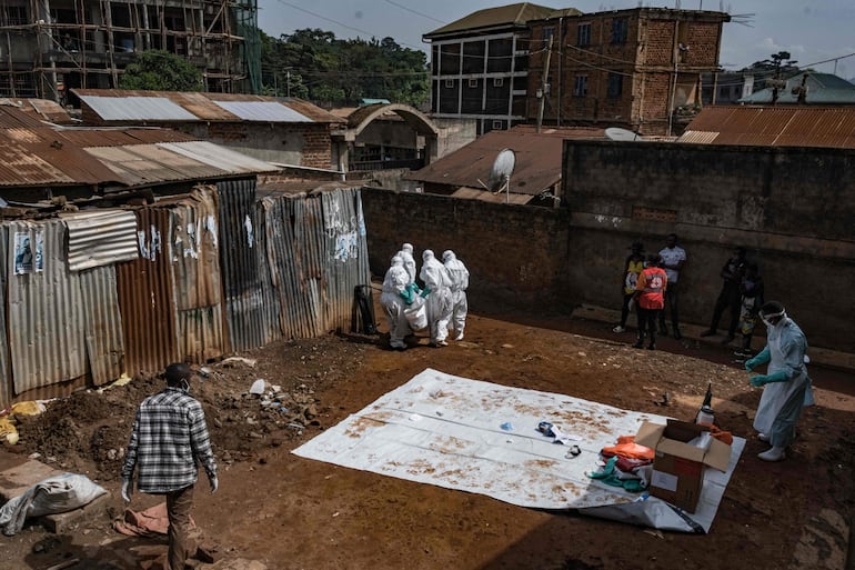 Trabajadores de la Sociedad de la Cruz Roja de Uganda evacúan el cuerpo de una presunta víctima de ébola en Kampala el 26 de mayo de 2026.