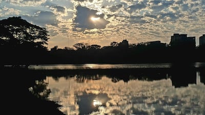 Paisaje con lago reflejando el cielo nublado y árboles alrededor, generando un ambiente de tranquilidad.